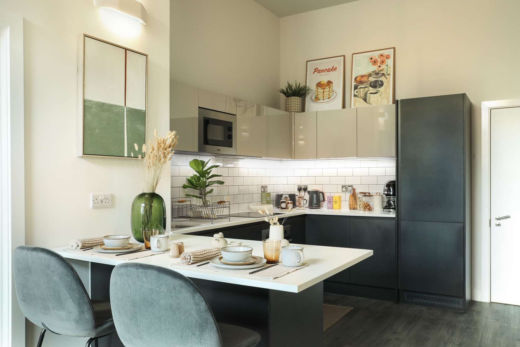 Stylish living area at Cortland Birmingham with large windows, green accent walls and contemporary furnishings.