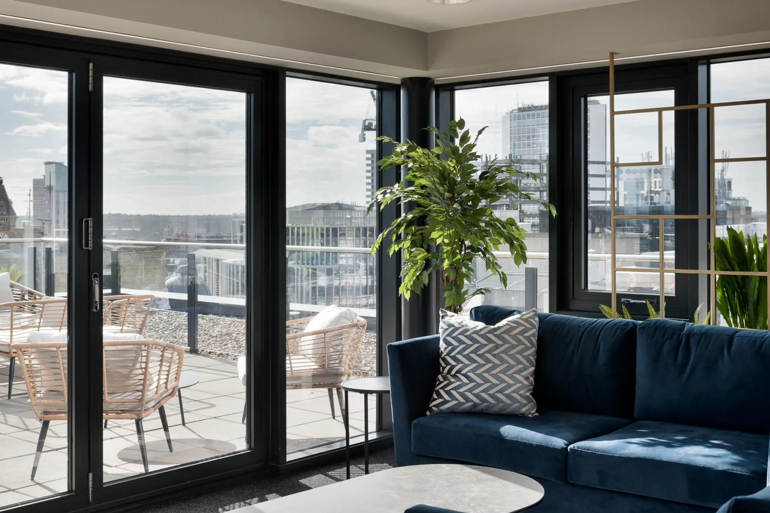 Bright lounge at Landrow Place Birmingham with floor-to-ceiling windows and private terrace views.