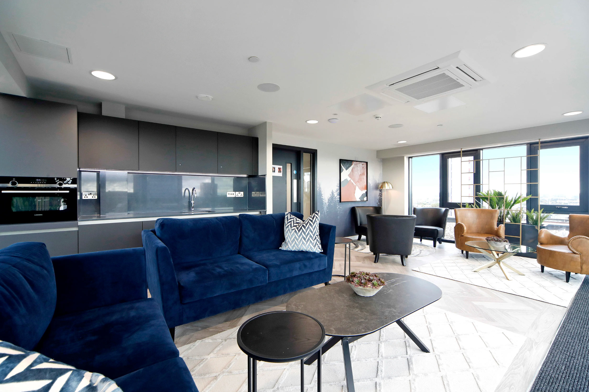 Contemporary resident lounge at Landrow Place Birmingham with modern furnishings and large windows.