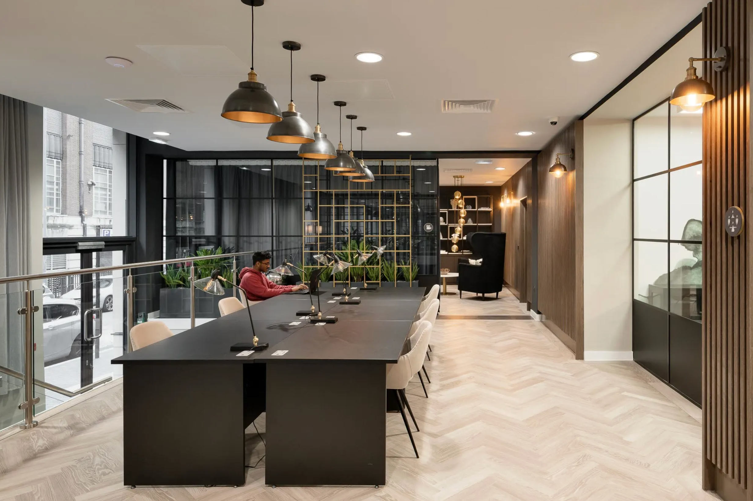 Modern coworking space at Landrow Place Birmingham featuring shared desks, pendant lighting and street views.